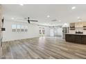 Bright living room boasts wood floors, neutral paint, a ceiling fan, modern kitchen, and access to the backyard at 2265 E Elmwood St, Mesa, AZ 85213