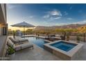 Inviting backyard pool and spa featuring lounge chairs, outdoor kitchen, and scenic mountain views, perfect for entertaining at 3703 S Avenida De Angeles --, Gold Canyon, AZ 85118
