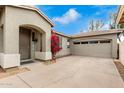 Tan house with a two-car garage and red flowers at 5185 S Eileen Dr, Chandler, AZ 85248