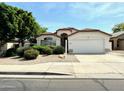 Charming single-story home features a well-maintained lawn, mature tree, and an attached two-car garage at 9829 E Onza Ave, Mesa, AZ 85212