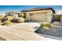 Two-car garage with a driveway and desert landscaping at 17103 S 182Nd Ln, Goodyear, AZ 85338