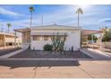 Front view of a white manufactured home with a carport and desert landscaping at 201 S Greenfield Rd # 142, Mesa, AZ 85206