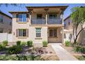 Two-story home with balcony, landscaping, and a walkway at 29068 N 124Th Dr, Peoria, AZ 85383