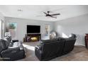 Comfortable living room with a fireplace and large TV at 31271 N 133Rd Dr, Peoria, AZ 85383