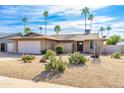 One-story brick home with a two-car garage and xeriscaping at 5909 E Crocus Dr, Scottsdale, AZ 85254