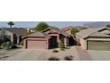 Single-story house with a two-car garage, desert landscaping, and mountain views in the background at 8944 E Red Mountain Ln, Gold Canyon, AZ 85118