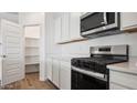 Modern kitchen with stainless steel appliances and white cabinets at 9868 S Caballo Dr, Apache Junction, AZ 85120