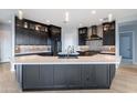 Modern kitchen with large island, dark cabinetry, and breakfast bar at 103 E Quartz Rock Rd, Phoenix, AZ 85085