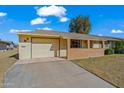 Ranch-style home with attached garage and a spacious driveway at 10632 W Roundelay Cir, Sun City, AZ 85351