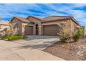 Two-car garage, tan exterior, and nicely landscaped front yard at 1727 N 213Th Dr, Buckeye, AZ 85396