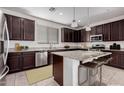 Beautiful kitchen featuring dark cabinets, stainless steel appliances, and an island with granite countertops at 1727 N 213Th Dr, Buckeye, AZ 85396