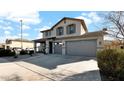 Two-story house with gray siding, a three-car garage, and a landscaped front yard at 18225 W Foothill Dr, Surprise, AZ 85387