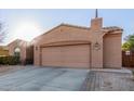 Tan house with a two-car garage and a well-maintained front yard at 23918 N 163Rd Dr, Surprise, AZ 85387