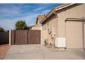Side yard with a wooden gate and part of the garage at 3410 N 131St Ln, Litchfield Park, AZ 85340