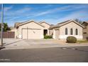 Tan two-story house with a three-car garage and landscaping at 3410 N 131St Ln, Litchfield Park, AZ 85340