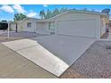 Light-colored house with a large two-car garage and gravel driveway at 5113 E Florian Ave, Mesa, AZ 85206