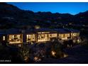 Luxury home at night nestled in the mountains with city views at 5939 E Quartz Mountain Rd, Paradise Valley, AZ 85253