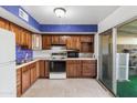 Cozy kitchen featuring wood cabinets, tiled floors, and modern appliances at 8220 E Garfield St # M20, Scottsdale, AZ 85257