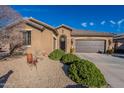 Tan colored house with a two-car garage and desert landscaping at 16140 W Almeria Rd, Goodyear, AZ 85395