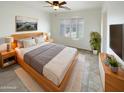 Spacious main bedroom with wood platform bed and large window with shutters at 16530 N 114Th Dr, Surprise, AZ 85378