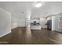 Spacious living room with wood-look floors and kitchen access at 41096 W Jenna Ln, Maricopa, AZ 85138