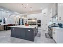 Modern kitchen features a large island, stainless steel appliances, and white cabinetry at 23807 N 64Th Ave, Glendale, AZ 85310