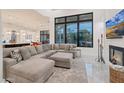 Spacious living area features a sectional sofa, fireplace, and large windows with pool view at 23807 N 64Th Ave, Glendale, AZ 85310