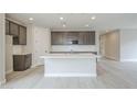 Modern kitchen featuring gray cabinets, a white island, and stainless steel appliances at 24177 W Hilton Ave, Buckeye, AZ 85326
