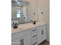 Modern bathroom with double sink vanity, quartz countertops, and dark hardware at 31363 N 130Th Ave, Peoria, AZ 85383