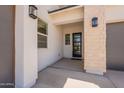 Covered entrance with stone siding, pendant lights, and a black front door at 11029 E Ulysses Ave, Mesa, AZ 85212