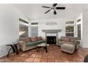 Living room with tiled floors, fireplace, and ceiling fan at 1220 N Cliffside Dr, Gilbert, AZ 85234
