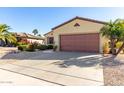 Single-story house with a brown garage door and drought-tolerant landscaping at 15041 W Wrigley Way, Surprise, AZ 85374