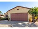 Front view of a single-story house with a brown garage door at 15041 W Wrigley Way, Surprise, AZ 85374