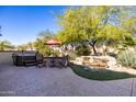 Relaxing backyard oasis with a hot tub, waterfall feature, and patio seating at 16336 W Salado Creek Dr, Surprise, AZ 85387