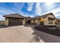 Tan house with brown roof and a brick driveway, nicely landscaped at 7130 W Rowel Rd, Peoria, AZ 85383