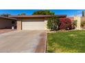 House exterior featuring a beige color scheme and well-maintained lawn at 10322 W Manzanita Dr, Sun City, AZ 85373