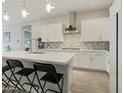Modern kitchen with white cabinets, quartz countertops, and island with seating at 13172 N 174Th Dr, Surprise, AZ 85388