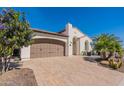 Home exterior with two-car garage and desert landscaping at 1806 E Azafran Trl, Queen Creek, AZ 85140
