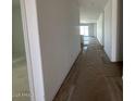 Hallway showcasing wood-look floors leading to kitchen with natural light at 22836 E Lords Way, Queen Creek, AZ 85142