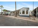 Mobile home exterior with carport and surrounding homes at 977 S Oxide Dr # 977, Apache Junction, AZ 85119