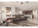 Open-concept living room with kitchen views and comfy sofas at 21778 N 259Th Ln, Buckeye, AZ 85396