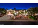 Beautiful Spanish style home with lush landscaping at night at 23206 N Del Monte Dr, Sun City West, AZ 85375