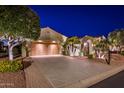 Luxury home with driveway and landscaped front yard at night at 23206 N Del Monte Dr, Sun City West, AZ 85375