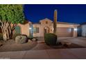 Night view of a single-story home with desert landscaping and a two-car garage at 26398 W Cat Balue Dr, Buckeye, AZ 85396