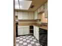 View of a kitchen with white cabinets, checkered floor, and black appliances at 3401 N 37Th St # 14, Phoenix, AZ 85018