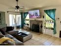 Cozy living room with large sectional sofa, fireplace, ceiling fan, and bright natural light at 1424 E Kerry Ln, Phoenix, AZ 85024
