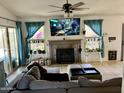 Bright living room featuring a fireplace, comfy seating, and a large TV at 1424 E Kerry Ln, Phoenix, AZ 85024
