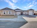 Modern home with a three-car garage and neutral color scheme at 18149 W Georgia Ct, Litchfield Park, AZ 85340