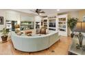 Open living room with built-in shelving and curved sofa at 24918 S Golfview Dr, Sun Lakes, AZ 85248