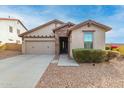 Tan house with stone accents, two-car garage, and landscaped yard at 29715 N 119Th Ln, Peoria, AZ 85383